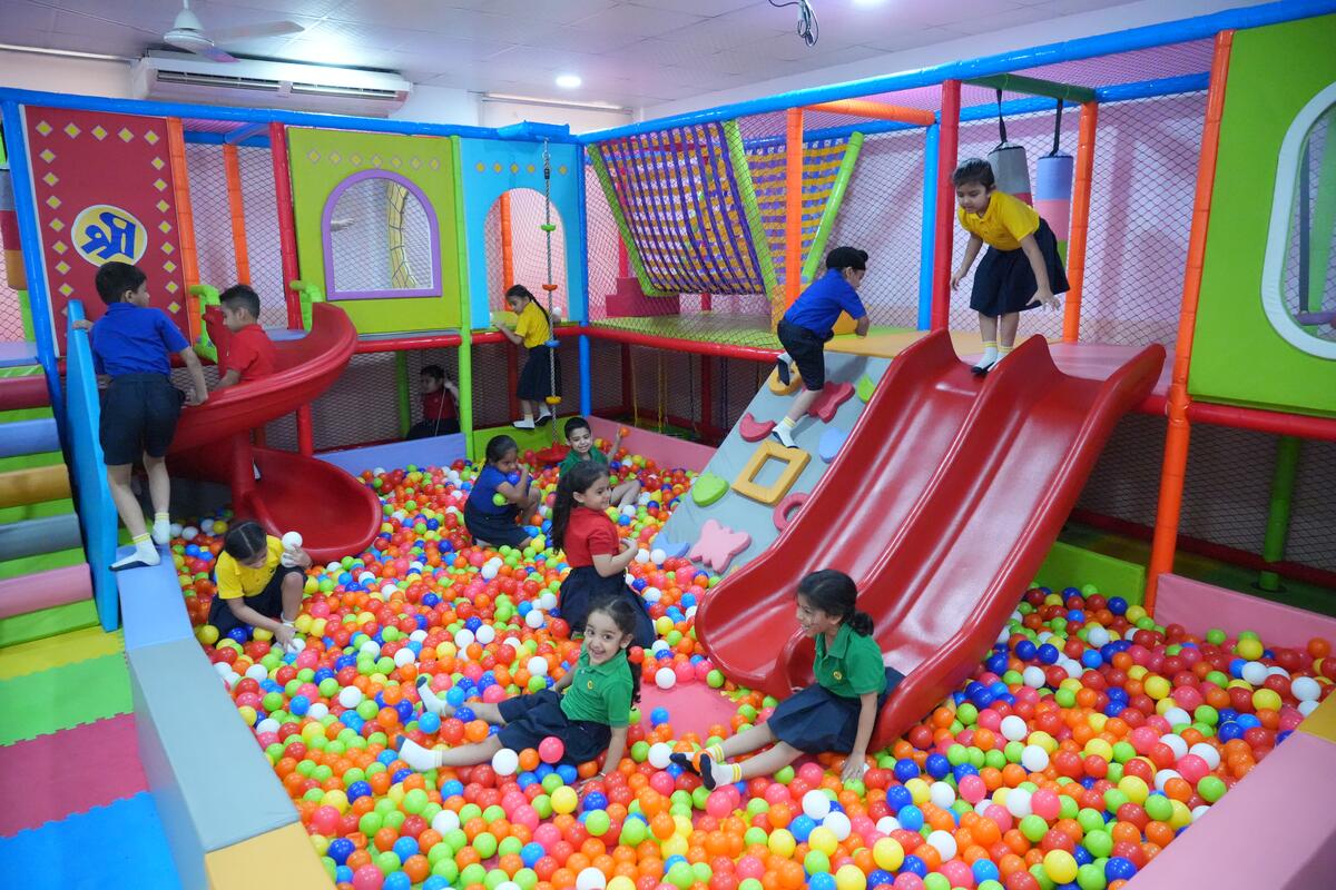 Children playing in the ball pool and on the slides of an indoor soft-play room at TSUS Sarabha Nagar